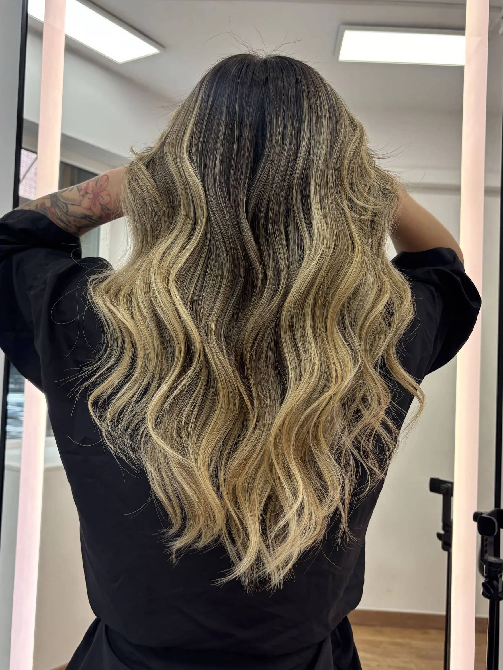 Balayage rubio en melena larga ondulada visto de espaldas en Barcelona