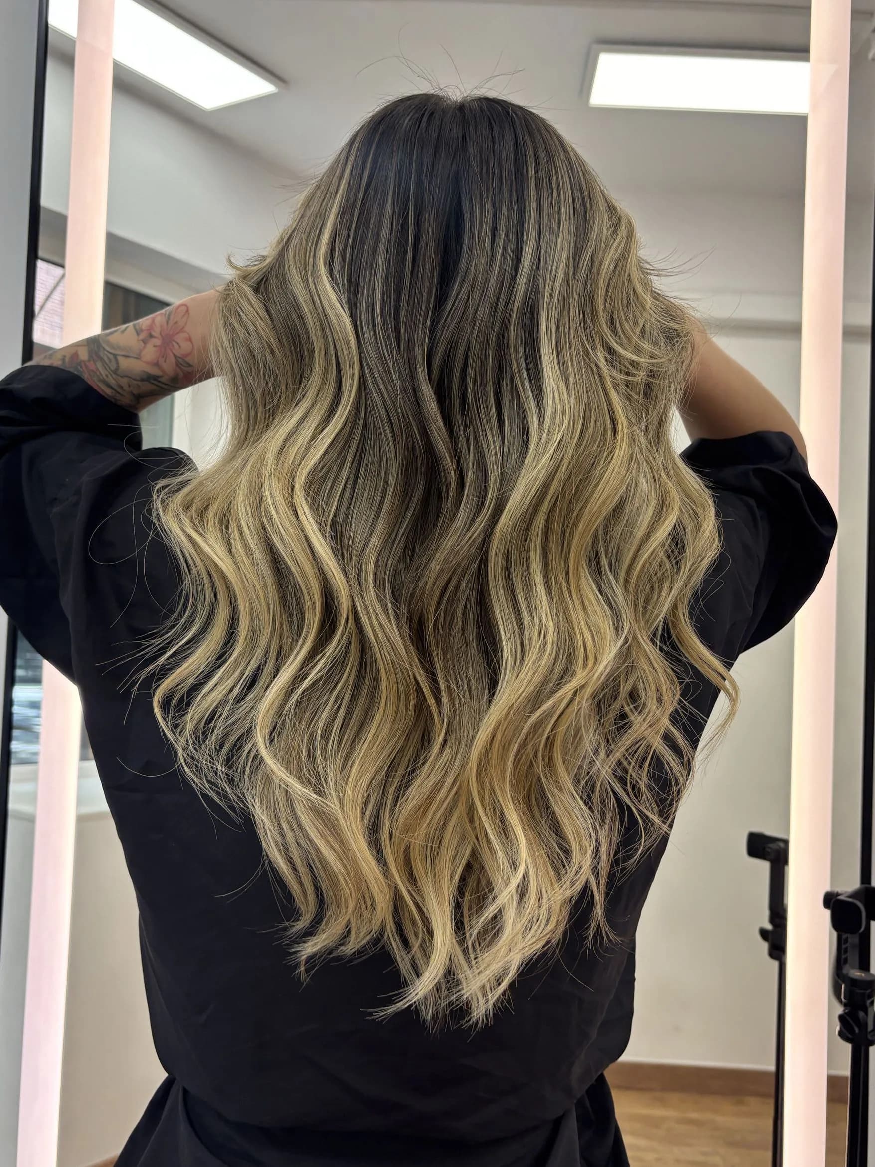 Balayage rubio en melena larga ondulada visto de espaldas en Barcelona